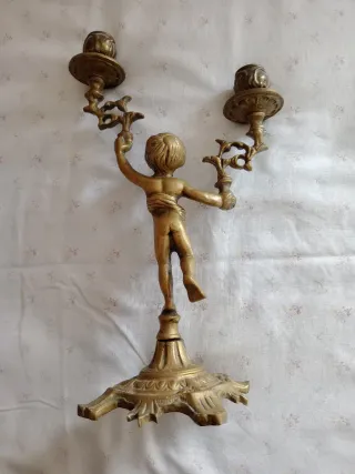 Candelabro in metallo dorato con putto