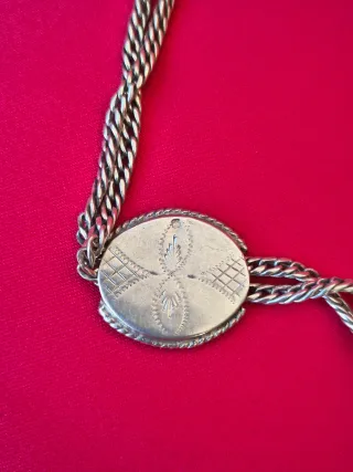 Cadena de reloj de bolsillo plata con colgante.