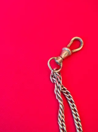 Cadena de reloj de bolsillo plata con colgante.