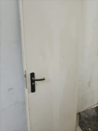 Puerta metálica blanca con manilla negra