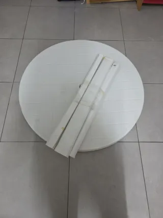 Mesa redonda exterior de plástico blanca.