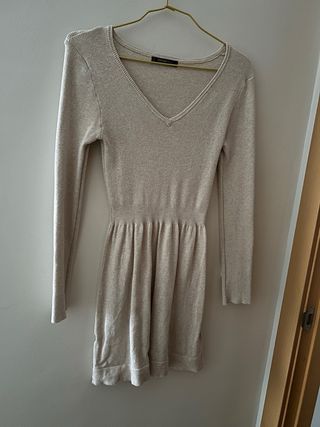 Vestido corto beige, mangas largas.