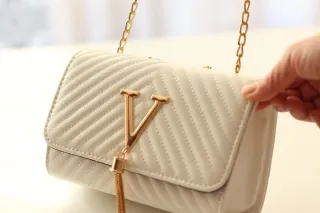 Bolso blanco con detalles dorados.