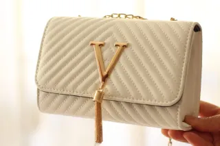 Bolso blanco con detalles dorados.