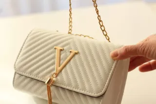 Bolso blanco con detalles dorados.