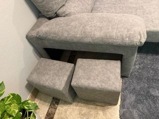 Sofá cama gris con 2 puffs