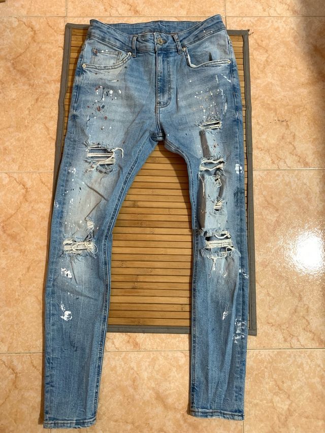 Jeans sfilacciati con pittura blu