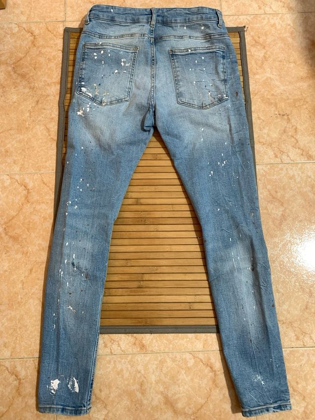 Jeans sfilacciati con pittura blu