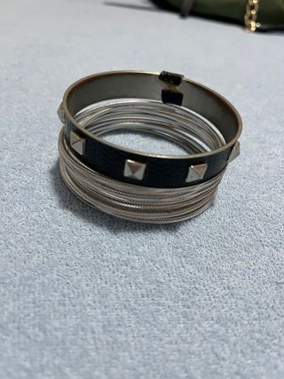 Set de pulseras plateadas y negras con tachuelas