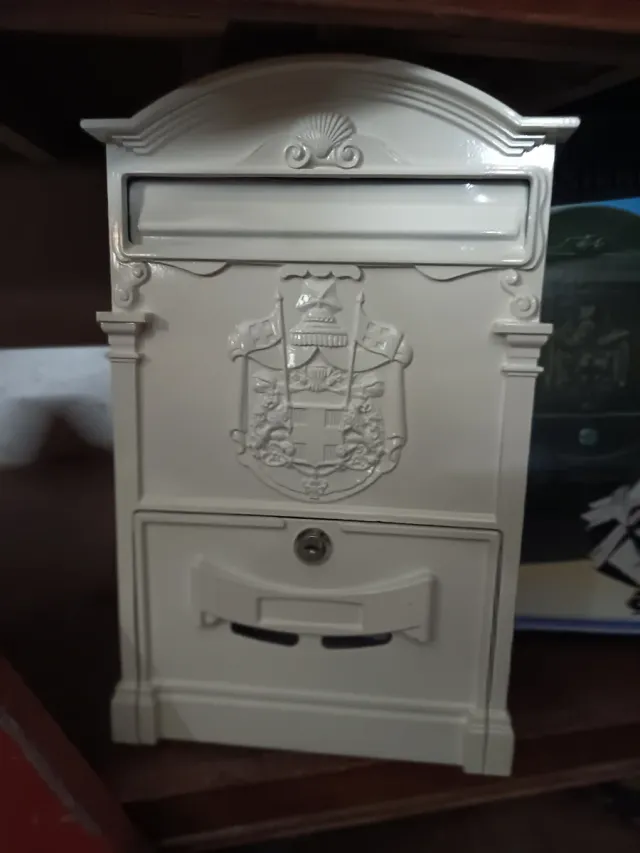 Buzón de correo blanco con escudo