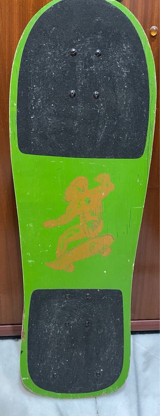 Skate verde con gráfico de surfista
