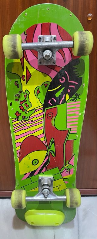 Skate verde con gráfico de surfista