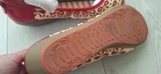 Zapatos planos beige y rojos con lazo