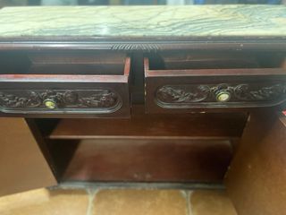 Mueble antiguo de madera tallada y mármol.