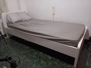 Cama individual blanca de madera, con colchón.