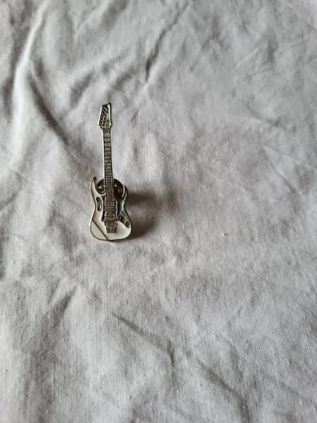 Pin guitarra plateado y blanco