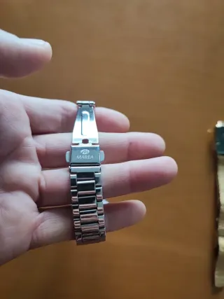 Reloj plateado con esfera rosa