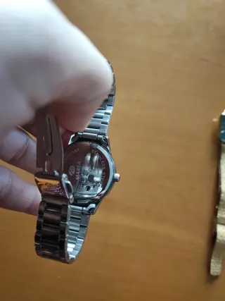 Reloj plateado con esfera rosa