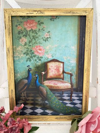 Quadro dorato con pavoni accanto a sedia vintage