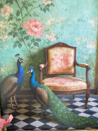 Quadro dorato con pavoni accanto a sedia vintage