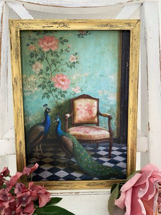 Quadro dorato con pavoni accanto a sedia vintage
