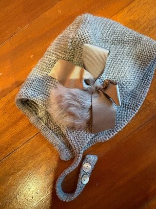 Gorro de punto gris con pompón y lazo