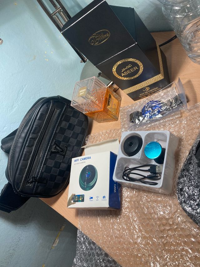 Caja con 4 artículos: Perfume, Cámara, Reloj,bolso