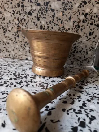 Mortero de bronce con mano