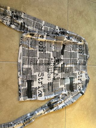 Top manga larga estampado periódico