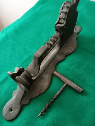 Antico cavatappi a muro in bronzo