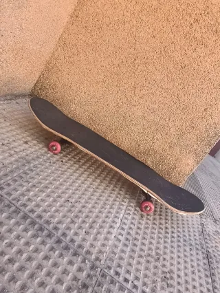 Patineta negra con ruedas rojas