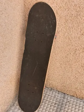 Patineta negra con ruedas rojas