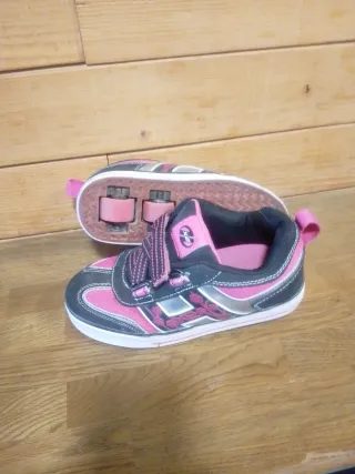 Zapatillas con ruedas Heelys rosas y negras.