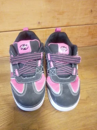 Zapatillas con ruedas Heelys rosas y negras.