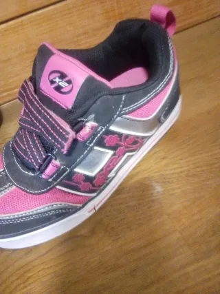 Zapatillas con ruedas Heelys rosas y negras.