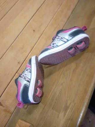 Zapatillas con ruedas Heelys rosas y negras.