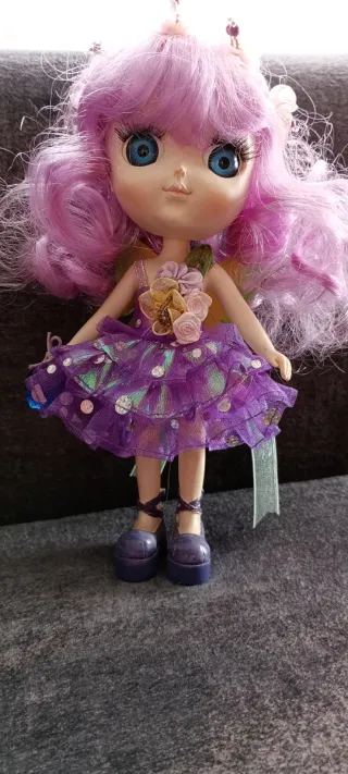 Muñeca de porcelana con vestido morado