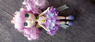 Muñeca de porcelana con vestido morado