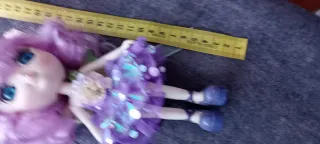 Muñeca de porcelana con vestido morado