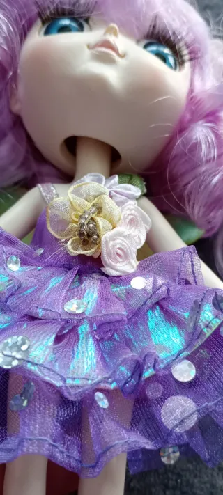 Muñeca de porcelana con vestido morado
