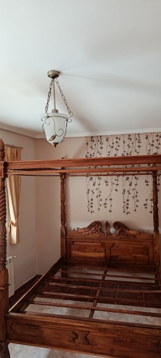 Cama con dosel de madera tallada
