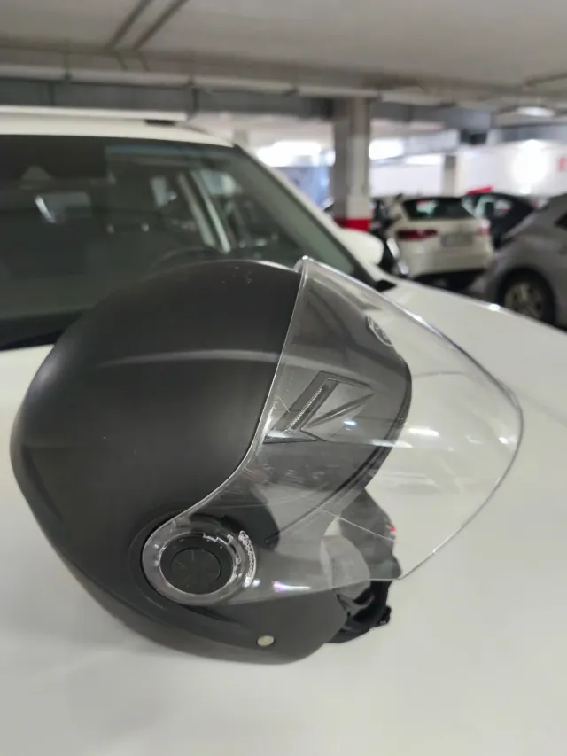 Casco de moto negro con visera y gafas solar