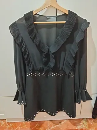 Vestido negro con volantes y tachuelas.