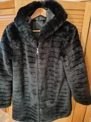 Abrigo imitación muton negro con capucha.