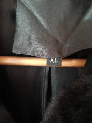 Abrigo imitación muton negro con capucha.