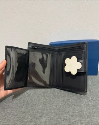 Cartera negra con flor blanca