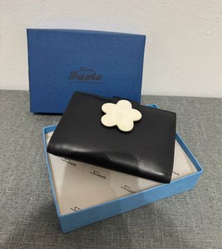 Cartera negra con flor blanca