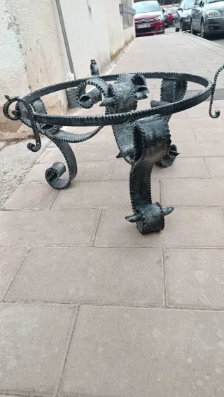 Mesa de centro forjado gris y cristal redondo.