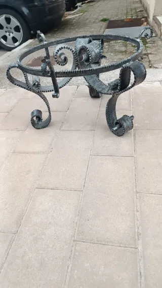 Mesa de centro forjado gris y cristal redondo.