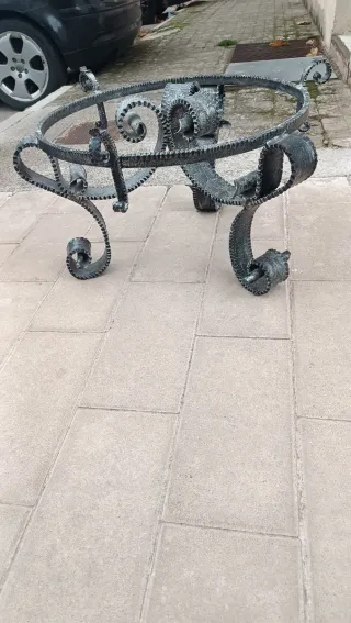 Mesa de centro forjado gris y cristal redondo.